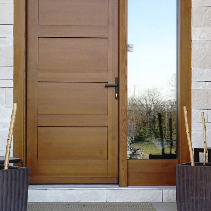 Brown wooden entrance door on brick house
